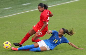 Brazil midfielder ADRIANA (14) makes a sliding tackle against Canada defender JAYDE RIVIERE (20) during the SheBelieves Cup Canada vs Brazil  match at Exploria Stadium in Orlando, Fl on February 24, 2021.