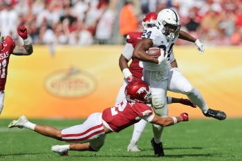 Penn State Nittany Lions running back KEYVONE LEE (24) gets tackled by Arkansas Razorbacks defensive back MYLES SLUSHER (2) during the Outback Bowl at Raymond James Stadium in Tampa, FL on January 1, 2022.