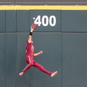 May 25, 2024; Charlotte, NC, USA; Florida State outfielder Max Williams (18) jumps for a catch against the wall in the sixth inning during the ACC Baseball Tournament against Wake Forest at Truist Field. Mandatory Credit: Cory Knowlton-USA TODAY Sports